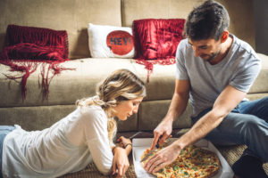 picture of young couple in home enjoying pizza delivery